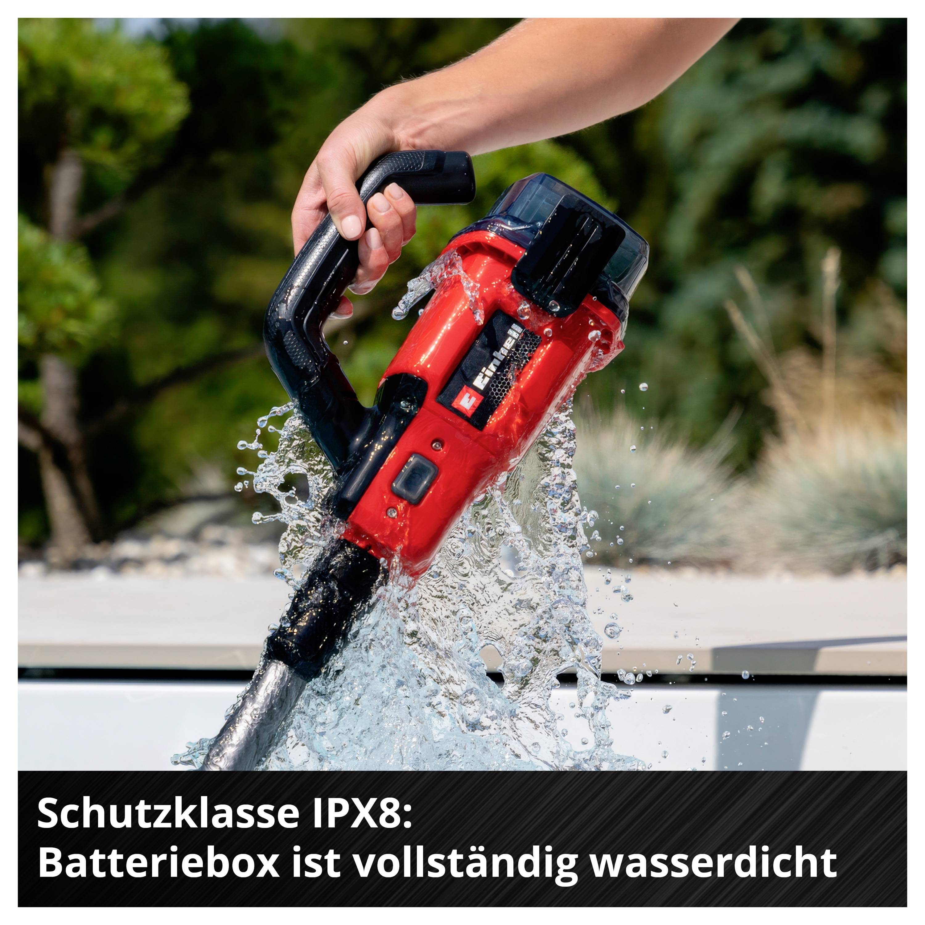 Hand hält eine rote Kettensäge unter Wasser; Text: 'Schutzklasse IPX8: Batteri(e)box ist vollständig wasserdicht'.
