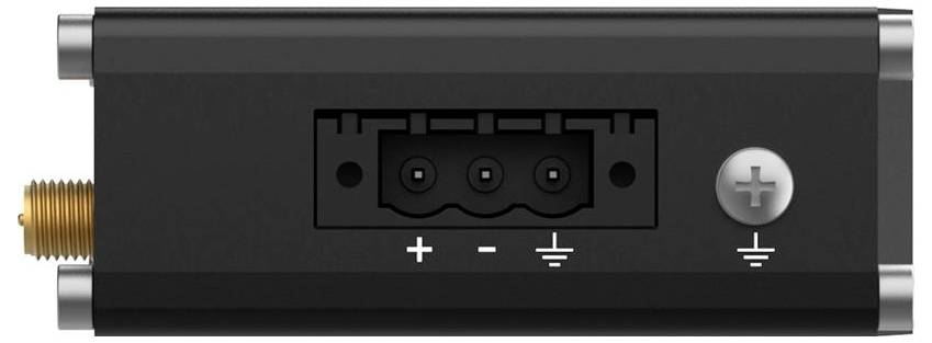Großaufnahme eines schwarzen elektrischen Steckermoduls mit Drei-Pol-Buchse und Erdungsschraube, beschriftet mit „+", „-" und Masse.