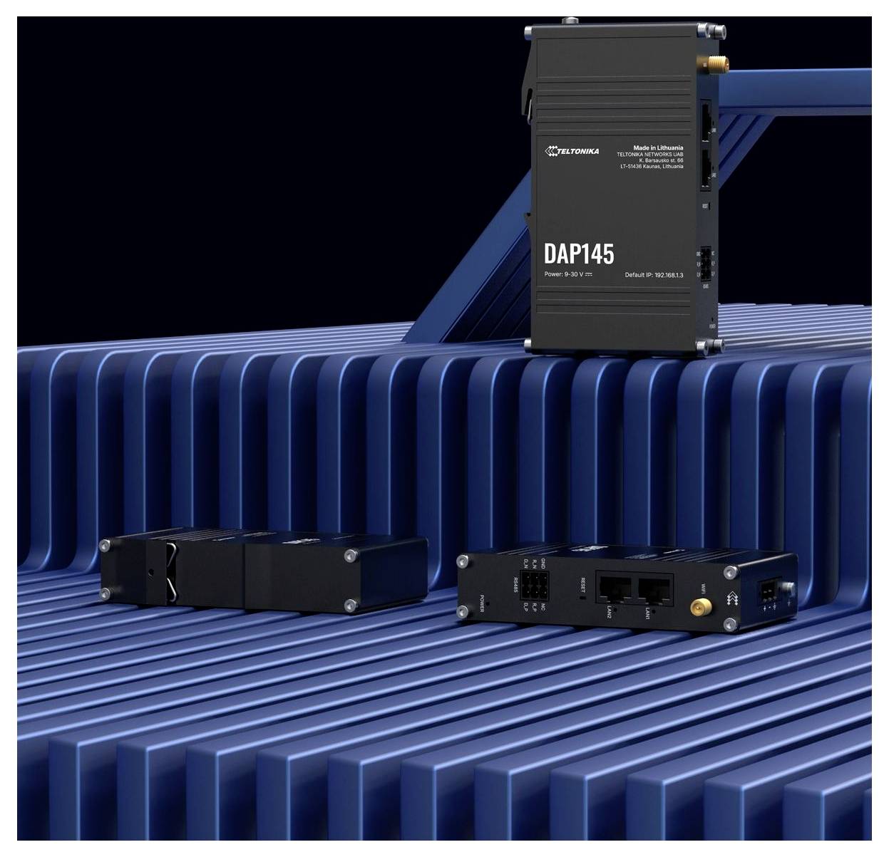 Drei schwarze elektronische Module auf einer blauen gerippten Oberfläche, einschließlich einer hohen Einheit mit der Bezeichnung „DAP145" und zwei kleineren Kommunikationsgeräten.
