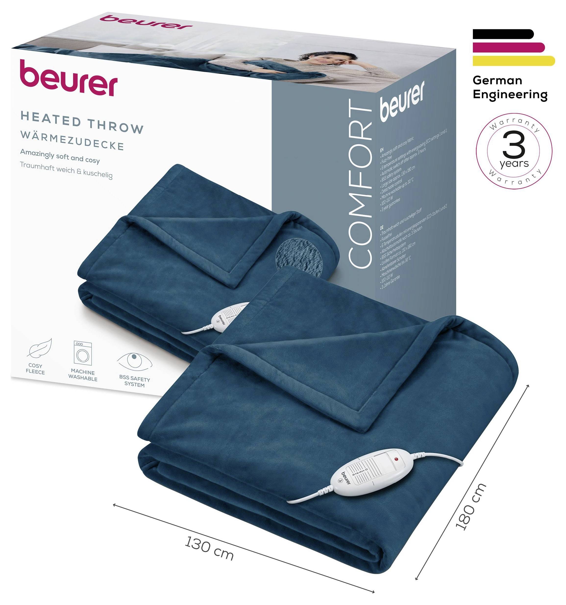 Produktbild einer beheizten Wurfdecke von Beurer in Blaugrün, gezeigt gefaltet mit schnurgebundenem Regler und Verpackung; gekennzeichnet mit 130 cm x 180 cm, 3 Jahre Garantie, deutsche Ingenieurskunst.