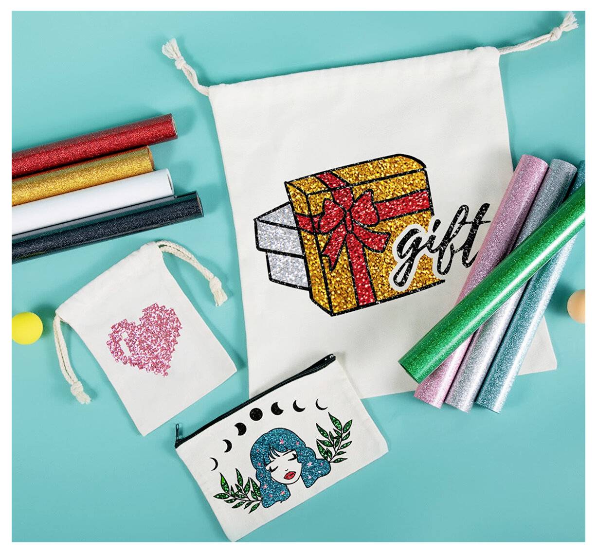 Bastelbedarf und kleine Zugbeutel verziert mit Glitzerdesigns, einschließlich einer Geschenkbox mit der Bezeichnung „Geschenk", einem rosa Herz und einem Frauengesicht mit Blättern.