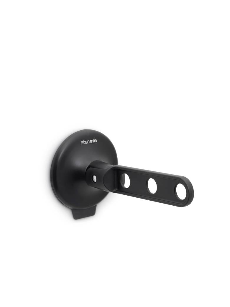 Schwarzer wandmontierter Toilettenpapierhalter mit kreisförmiger Basis und horizontalem Arm mit ovalen Aussparungen, auf weißem Hintergrund dargestellt.