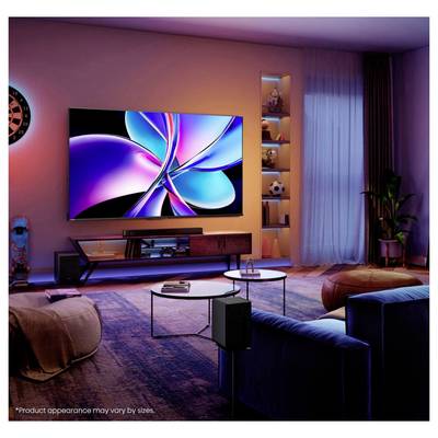 Modernes Wohnzimmer mit einem großen, wandmontierten Fernseher, der abstrakte bunte Grafiken anzeigt, Sofas, Couchtische, Regale und Umgebungsbeleuchtung.