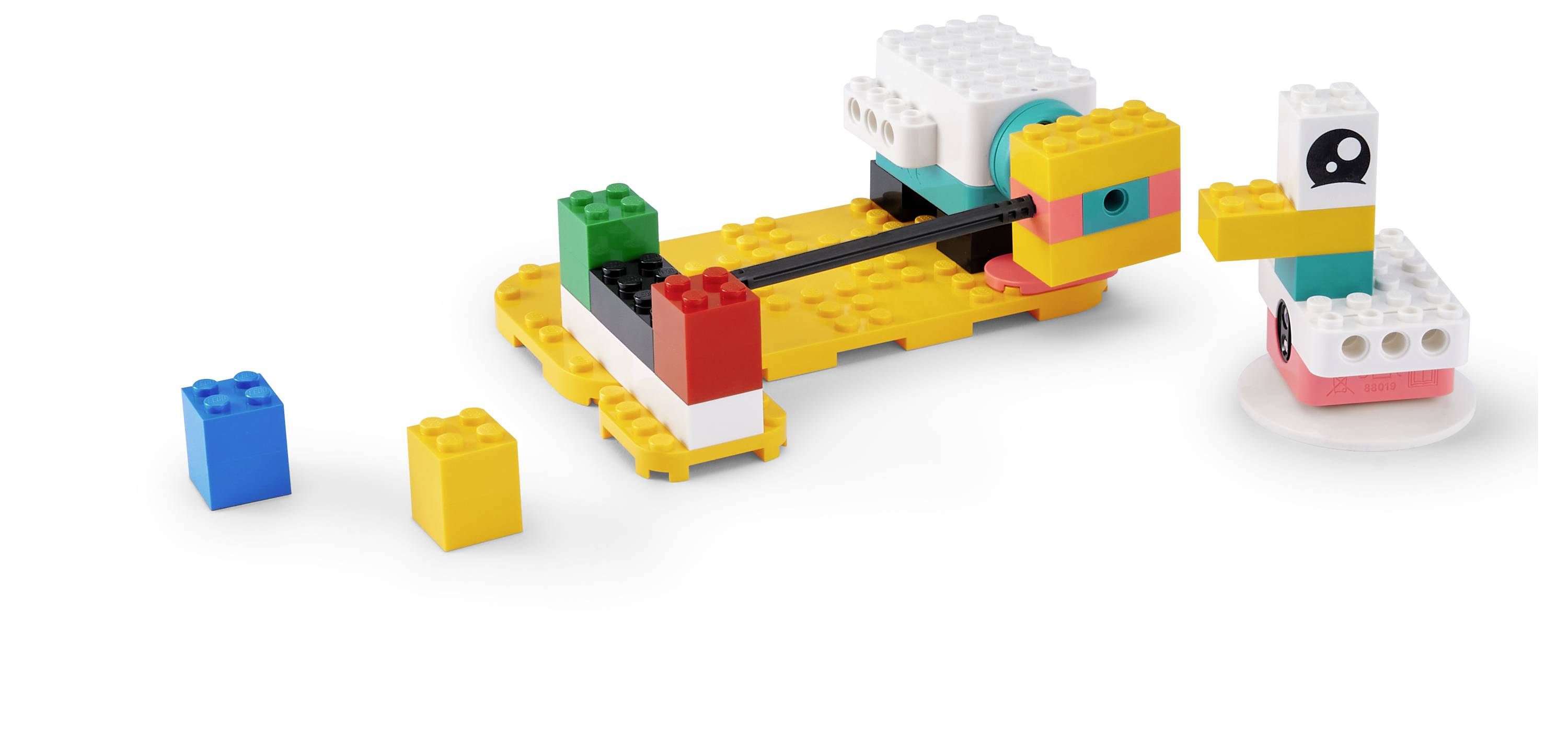 Bild von bunten Spielzeugbausteinen, die als zwei kleine zusammengebaute LEGO-ähnliche Fahrzeuge oder Plattformen auf weißem Hintergrund angeordnet sind, mit zwei losen Steinen davor.
