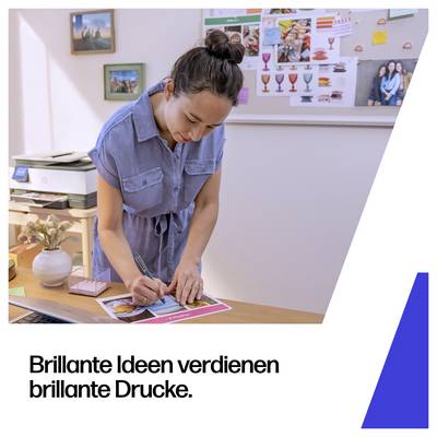 Frau schreibt an einer Broschüre an einem Schreibtisch in einem Büro, daneben deutscher Text „Brillante Ideen verdienen brillante Drucke."
