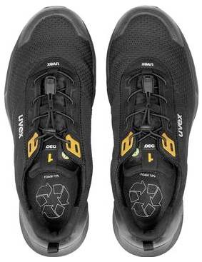 Paar schwarzer Vux-Schuhe von oben fotografiert, mit orangefarbenen Akzenten und Recycling-Symbolen auf den Innensohlen.