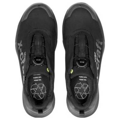 Paar schwarze Craft-Sportschuhe von oben auf weißem Hintergrund gezeigt, mit sichtbaren Markierungen aus recyceltem Material auf den Innensohlen.