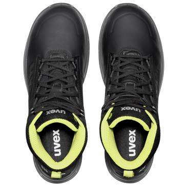 Paar schwarze Uvex-Sportschuhe/Arbeitsschuhe mit neongelben inneren Kragen, von oben auf weißem Hintergrund betrachtet.