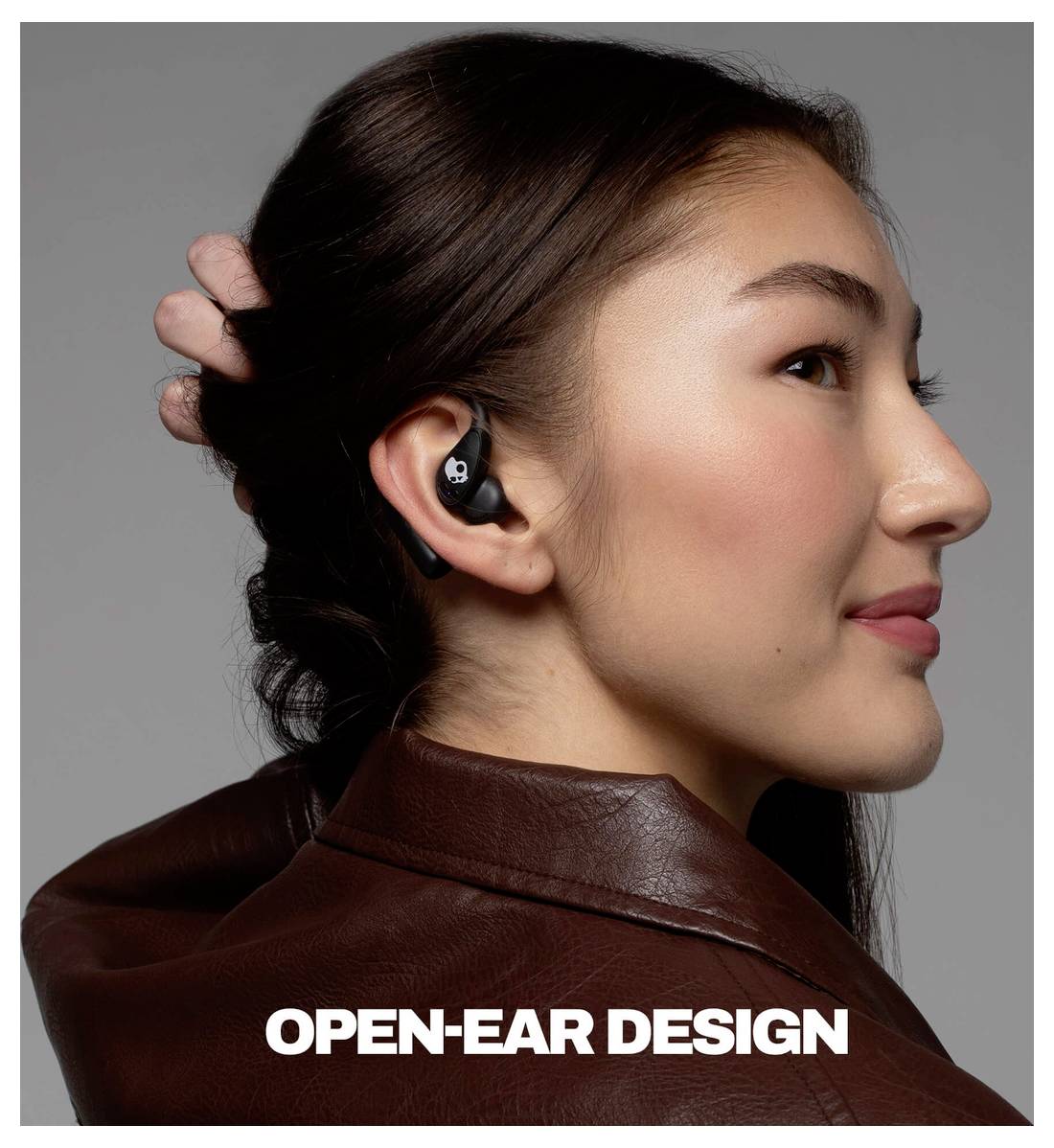 Profil einer Frau, die schwarze offene kabellose Ohrhörer trägt, mit dem Text „OPEN-EAR DESIGN" am unteren Ende.