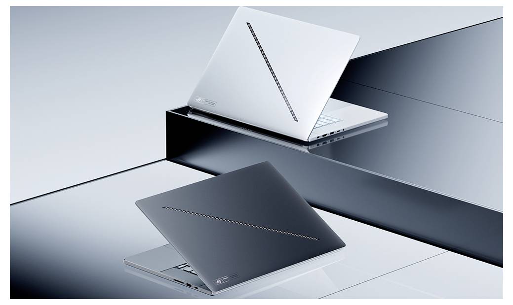 Zwei elegante Laptops, einer in Silber und einer in Dunkelgrau, aufgeklappt auf gestaffelten reflektierenden Plattformen in einer modernen Studioumgebung ausgestellt.