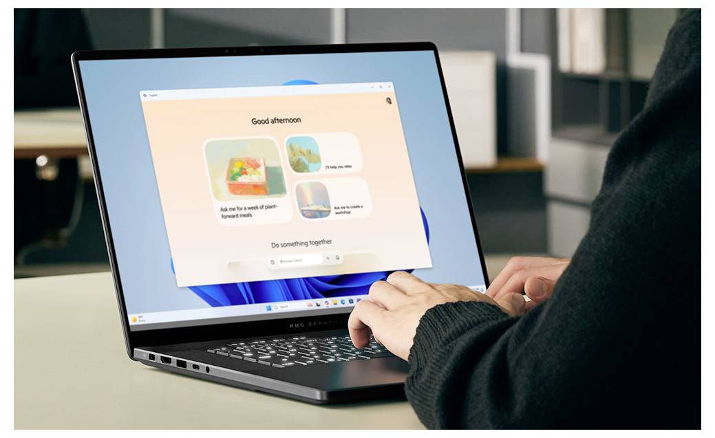 Person mit einem Laptop mit einem Windows-Willkommensbildschirm, auf dem "Guten Nachmittag" angezeigt wird und vorgeschlagene Aufgaben auf dem Display zu sehen sind.