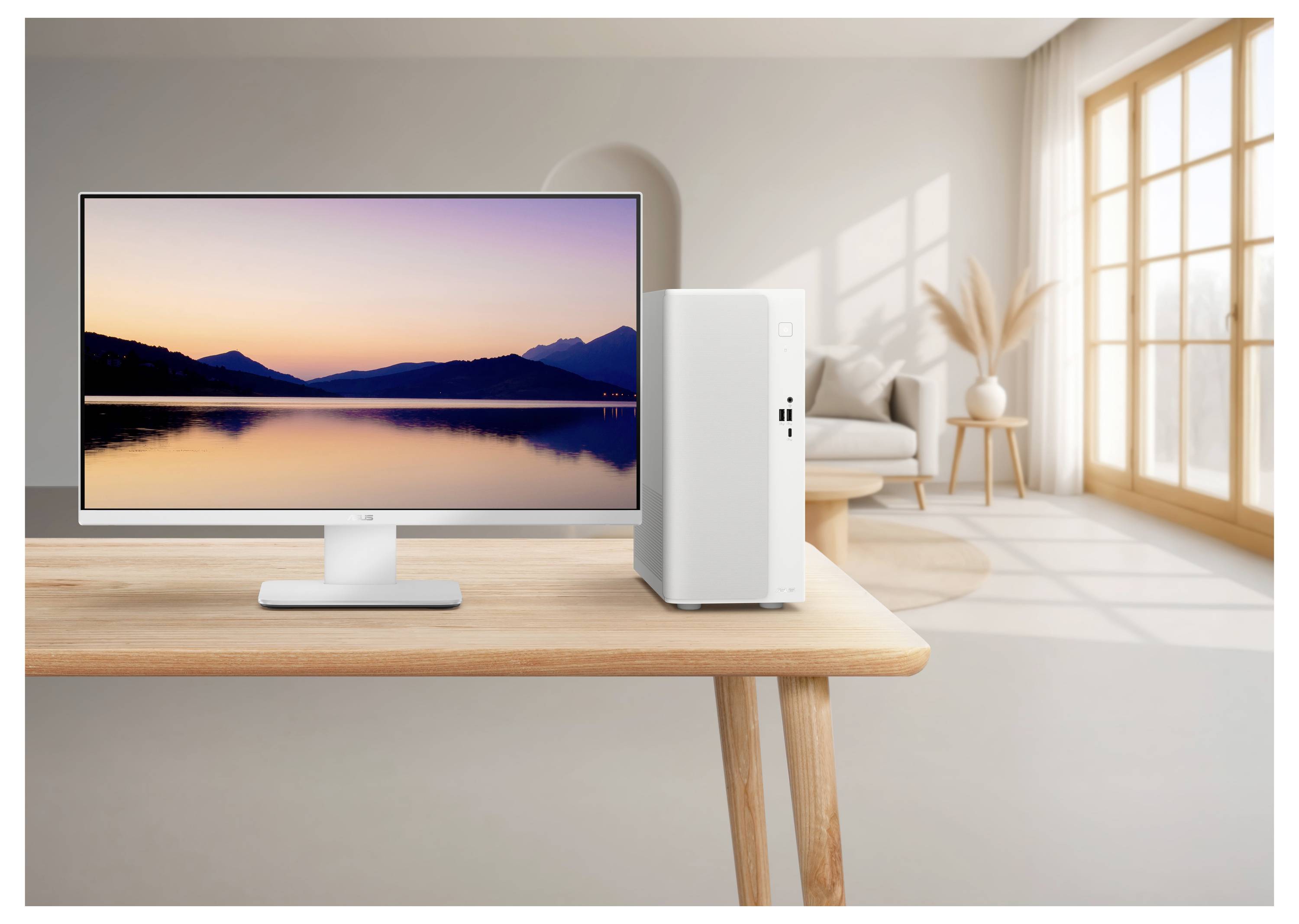 Desktopmonitor und Tower-PC auf einem Holztisch in einem hellen Wohnzimmer, mit einem ruhigen Sonnenuntergang-Seewallpaper auf dem Bildschirm.