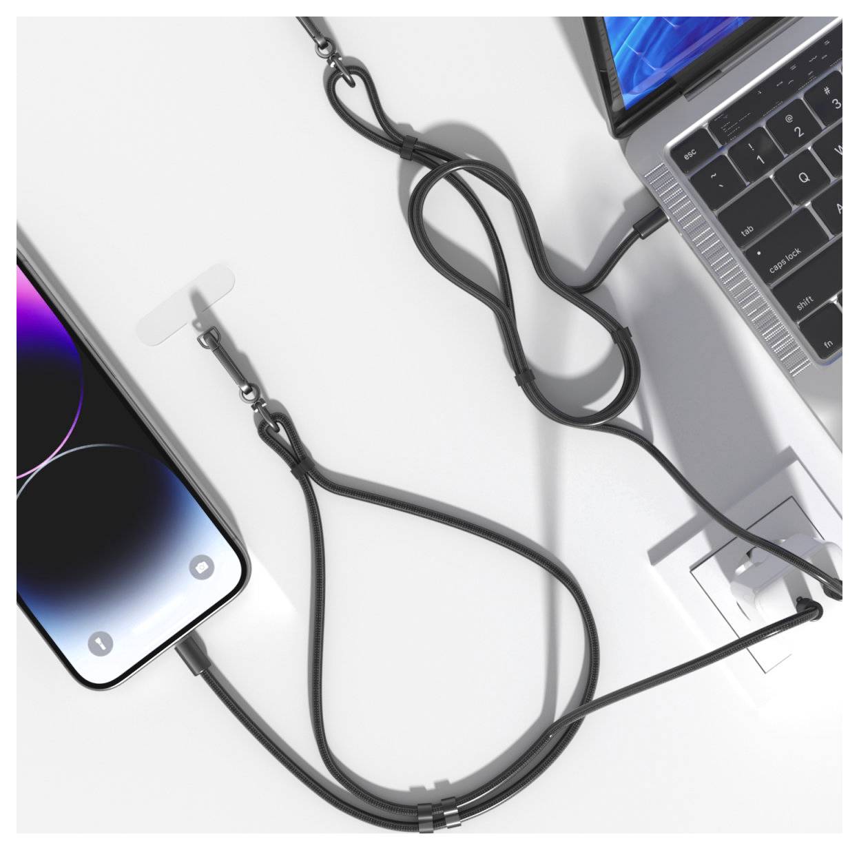 Smartphone und Laptop verbunden durch verwickelte Ladekabel auf einem weißen Schreibtisch, zeigt mehrere Geräte, die von einer Einrichtung mit Strom versorgt werden.