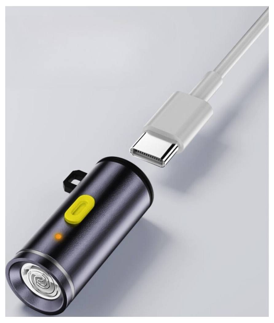 USB-C-Kabel verbunden mit einem kompakten schwarzen zylindrischen Gerät mit gelbem Knopf und Anzeigelicht auf hellgrauem Hintergrund.