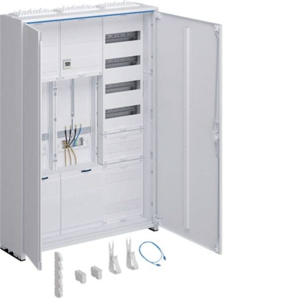 Offener Elektroverteilerschrank mit Verdrahtungskompartimenten und modularen Steckplätzen; lose Anschlusskomponenten und ein blaues Kabel liegen davor.