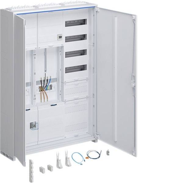 Offener weißer elektrischer Schaltschrank mit Verdrahtung und Terminalmodulen, Tür offen, mit Montagezubehör und Kabeln, die darunter ausgelegt sind.