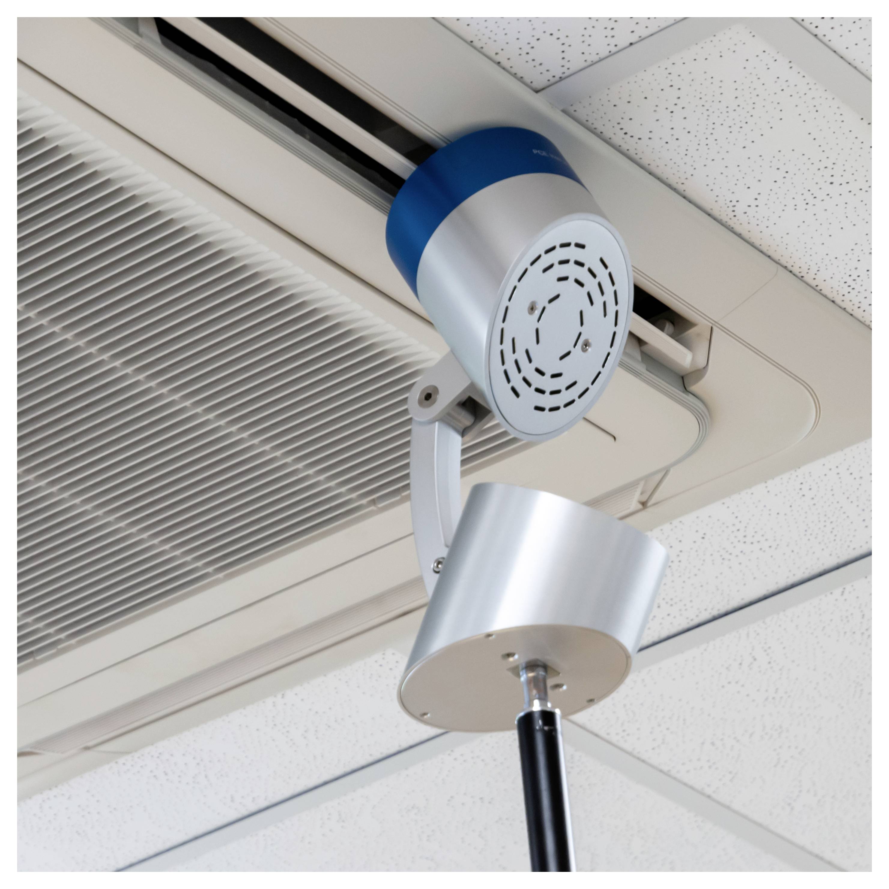 An der Decke montiertes medizinisches Abbildungsgerät mit zwei silbernen zylindrischen Komponenten auf einem verstellbaren Arm in einem klinischen Raum.
