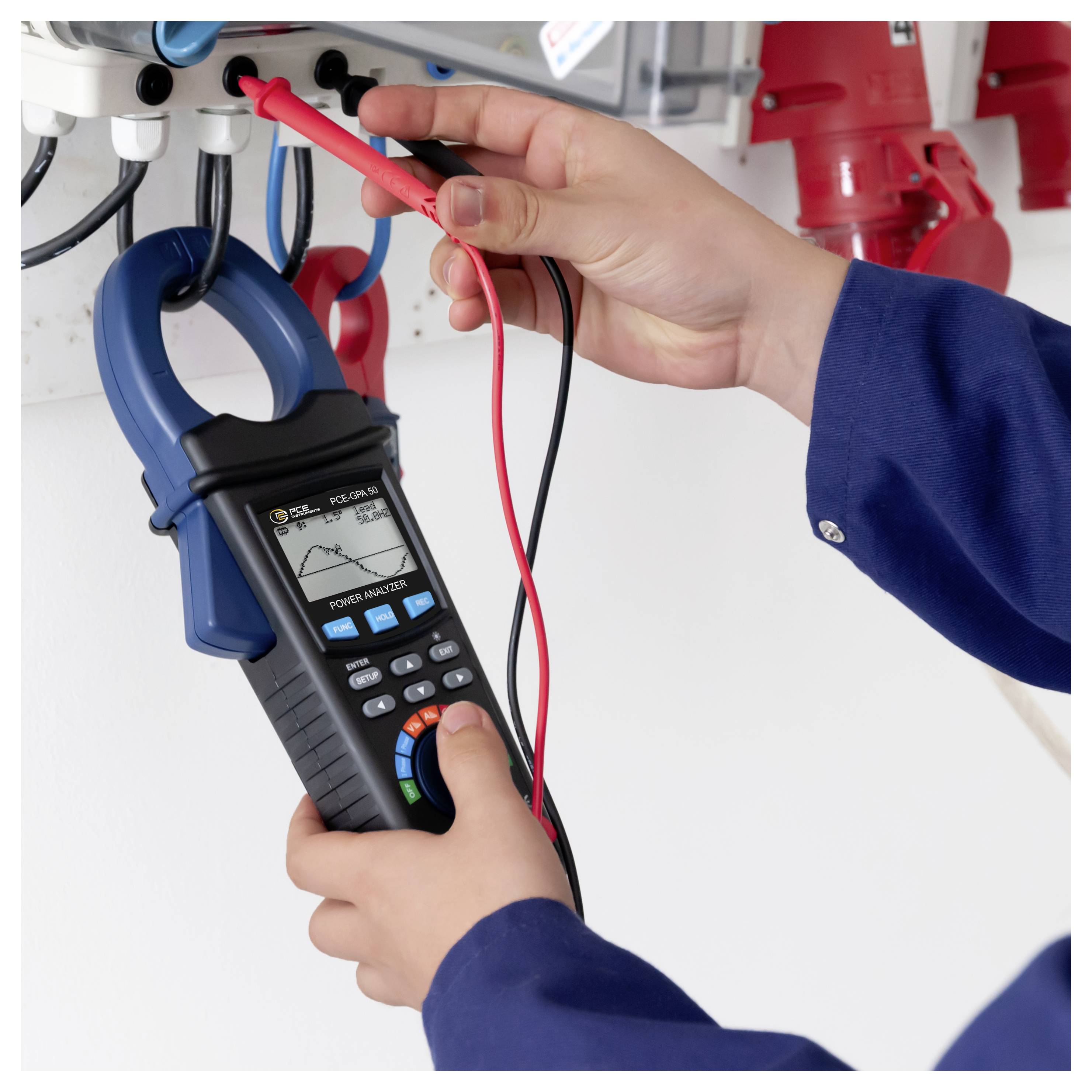 Der Techniker verwendet ein Zangenmessgerät und Messleitungen, um elektrische Leitungen in einem Bedienfeld zu messen.