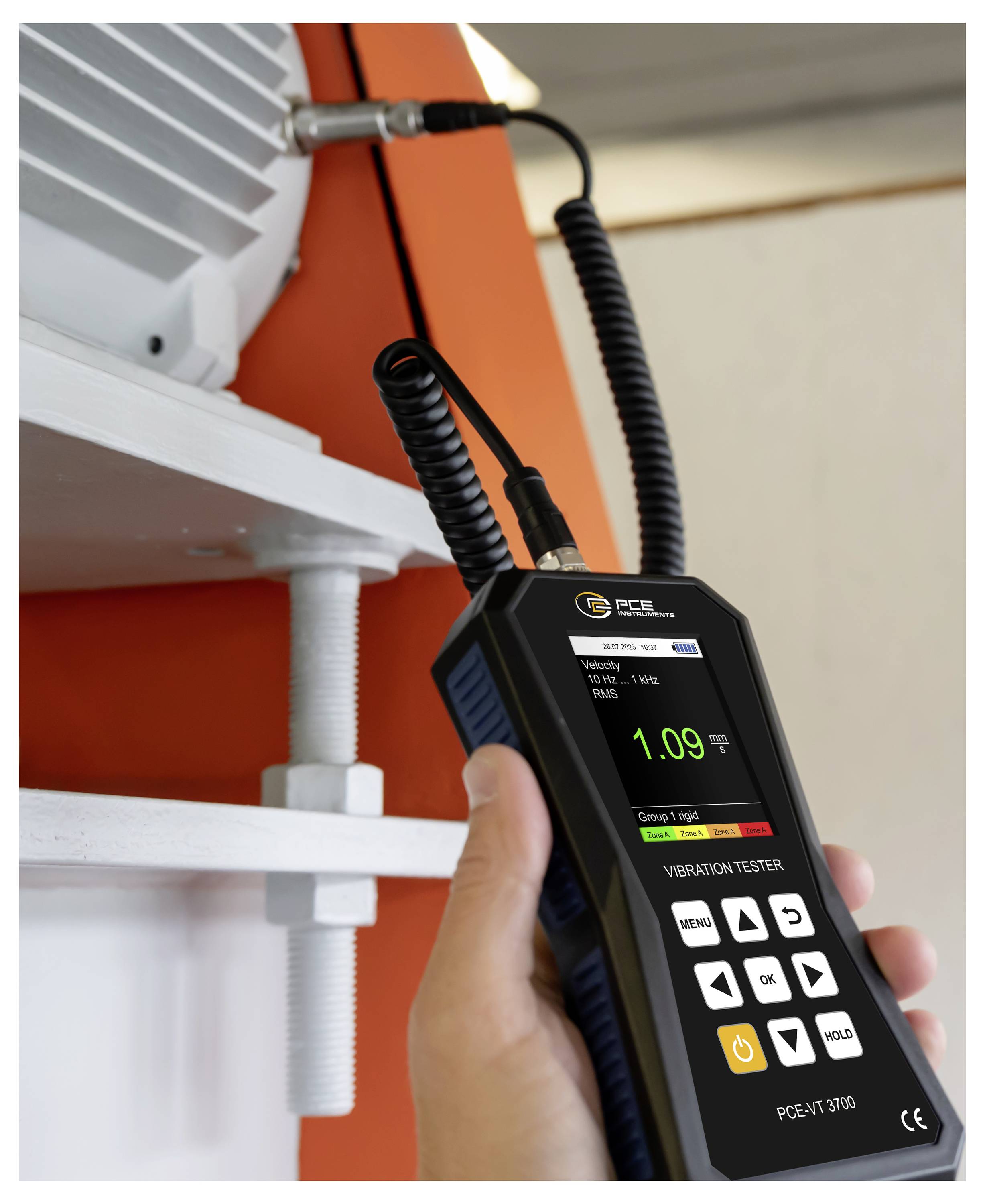 Tragbares Vibrationsprüfgerät mit einer Anzeige von 1,09 in der Nähe von montierter Maschine, mit an Ausrüstung angeschlossenem Messfühler-Kabel.
