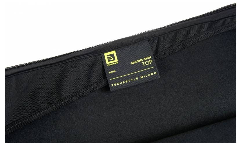 Nahaufnahme eines schwarzen Kleidungsetiketts mit gelbem Text, auf dem "SECOND SKIN TOP" und "TECHSTYLE MILANO" in eine Kleidungsnaht eingenäht sind.