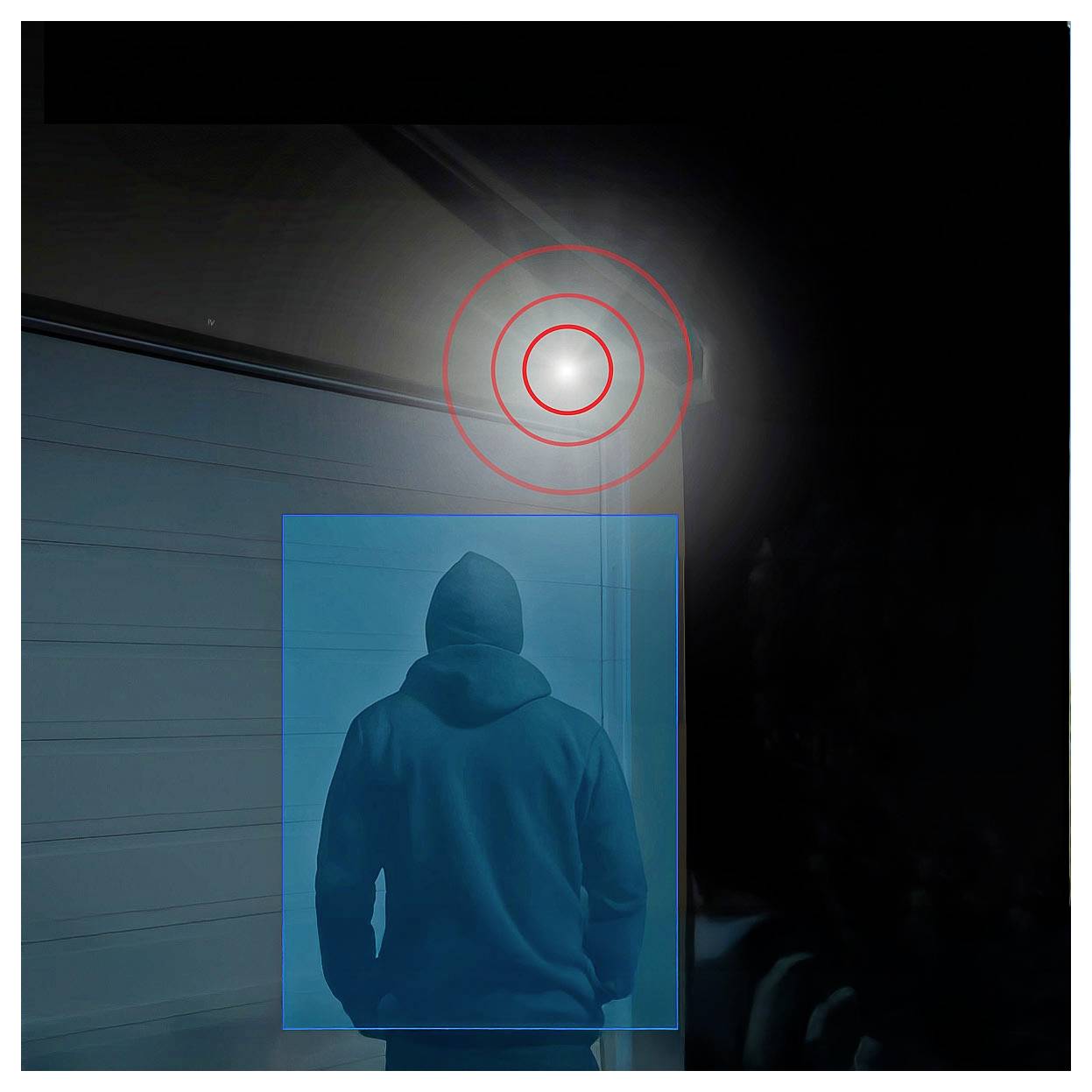 Person mit Kapuze, von hinten gesehen, in einer düsteren Garage oder Gasse, mit einem hellen Licht oben, das durch rote Kreise hervorgehoben wird, und die Figur in einem blauen Rahmen eingefasst.