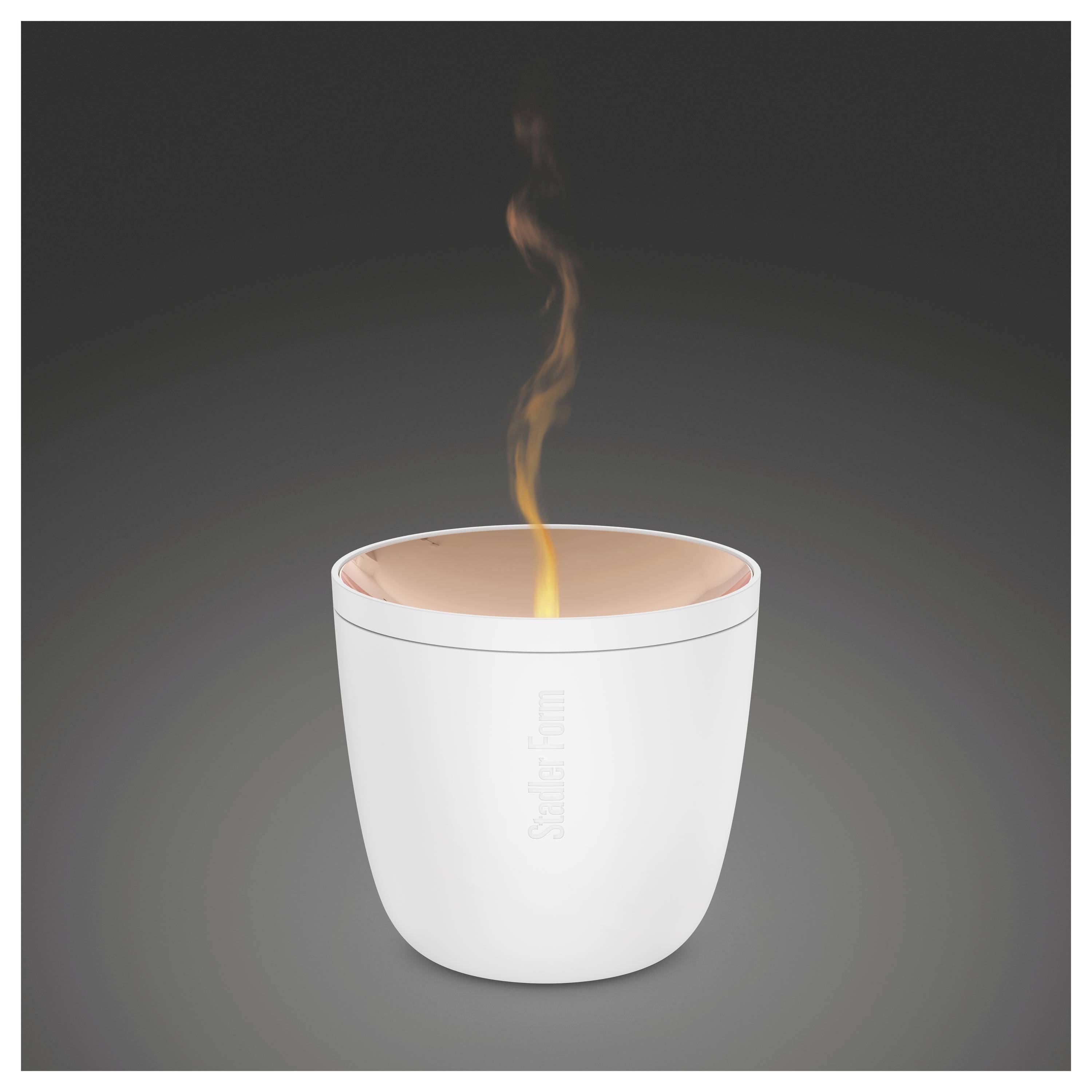 Weiße isolierte Tasse mit leuchtend orangem Inneren und Dampf, der von oben gegen einen dunklen Hintergrund aufsteigt.