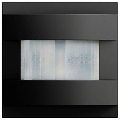 Dunkelgrau an der Wand montiertes Lüftungsgitter oder Lautsprecher mit einem zentralen mattglasierten Panel, das zwei kreisförmige Elemente dahinter zeigt.