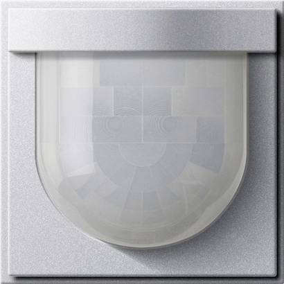 Wandmontierter Bewegungsmelder in silberfarbenem quadratischen Gehäuse mit transparenter Kuppellinse.