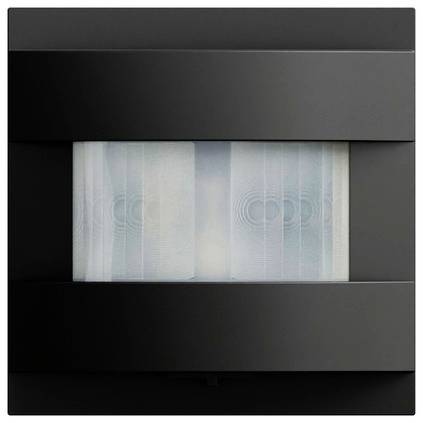 Schwarze wandmontierte Leuchte mit rechteckigem Milchglaspanel, das ein weiches kreisförmiges Lichtmuster dahinter zeigt.