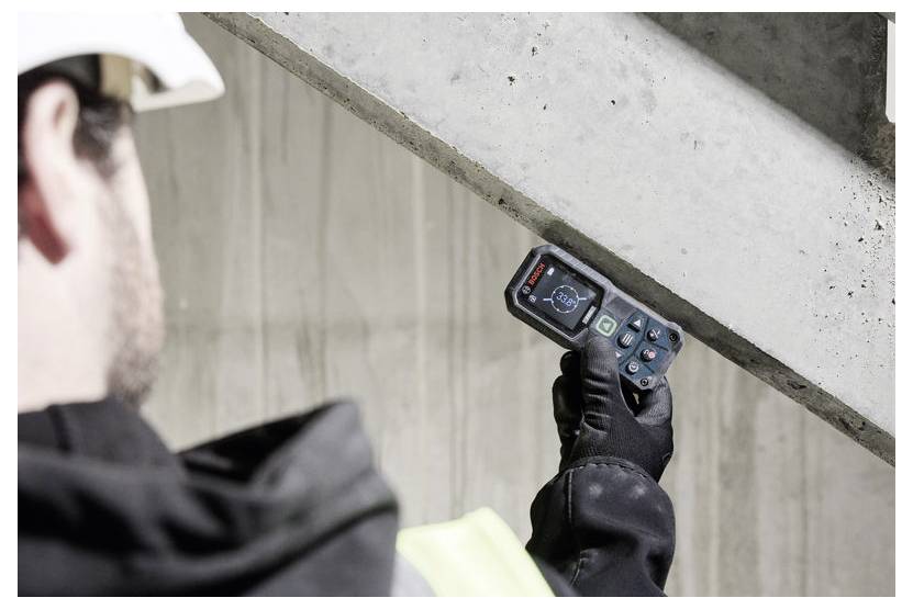 Arbeiter mit Schutzhelm nutzt ein tragbares Inspektionsgerät, um einen Betonbalken zu scannen und die Struktur auf Mängel zu überprüfen.