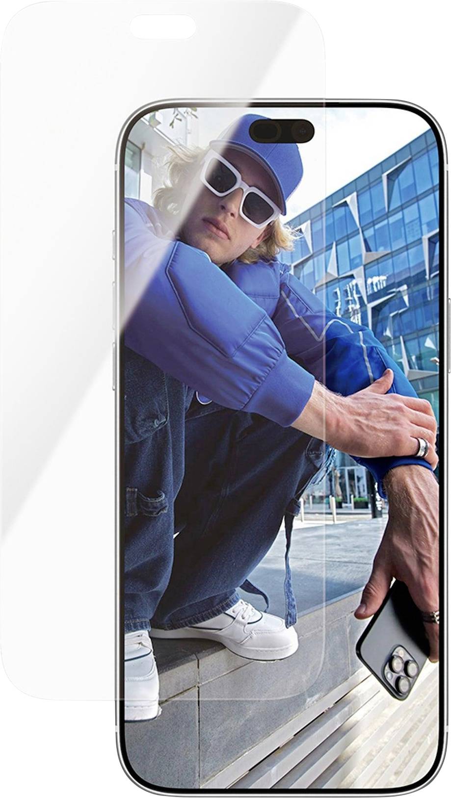 Smartphone zeigt ein Vollbildfoto einer jungen Person in blauer Straßenkleidung und weißer Sonnenbrille, die neben einem Glasgebäude hockt und ein Telefon hält.