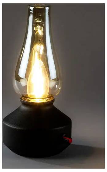 Eine glühende, im Vintage-Stil gestaltete Elektrolampe in einem klaren Glasgehäuse mit schwarzem Sockel und kleinem rotem Schalter.
