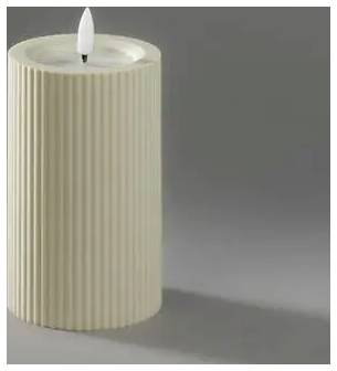 Hohe gerippelte beige Kerze mit weißem Docht auf grauem Hintergrund, unangezündet.