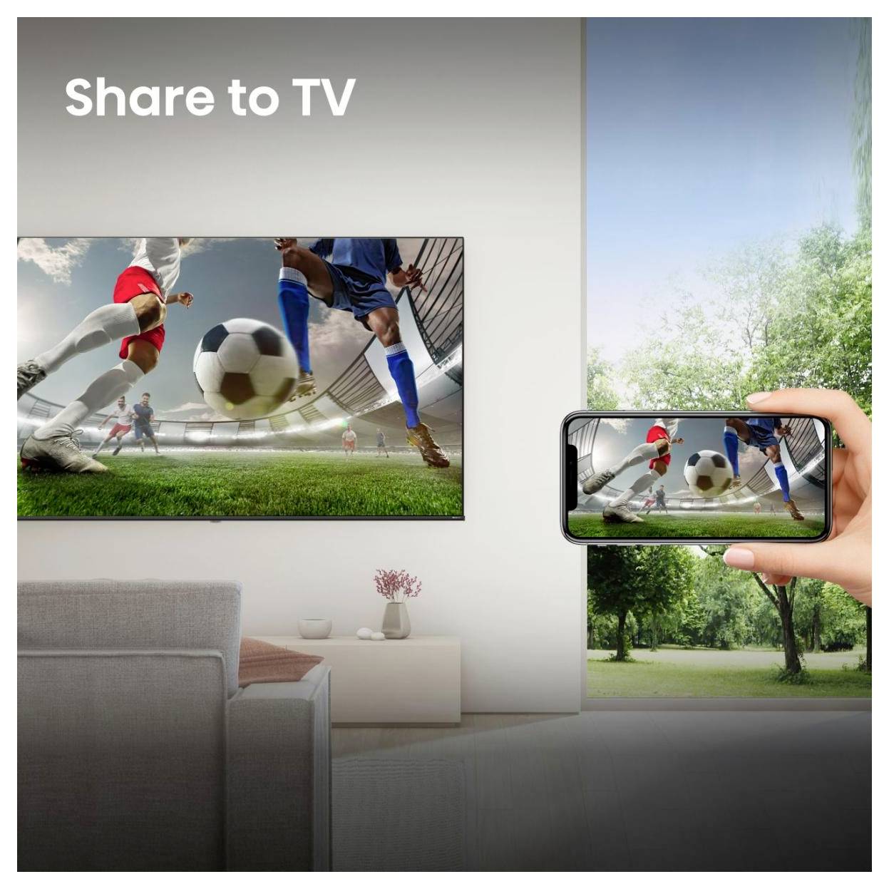 Wohnzimmer mit der Beschriftung „Auf TV übertragen", das ein Smartphone zeigt, das ein Fußballspiel auf einen an der Wand montierten Fernseher spiegelt.