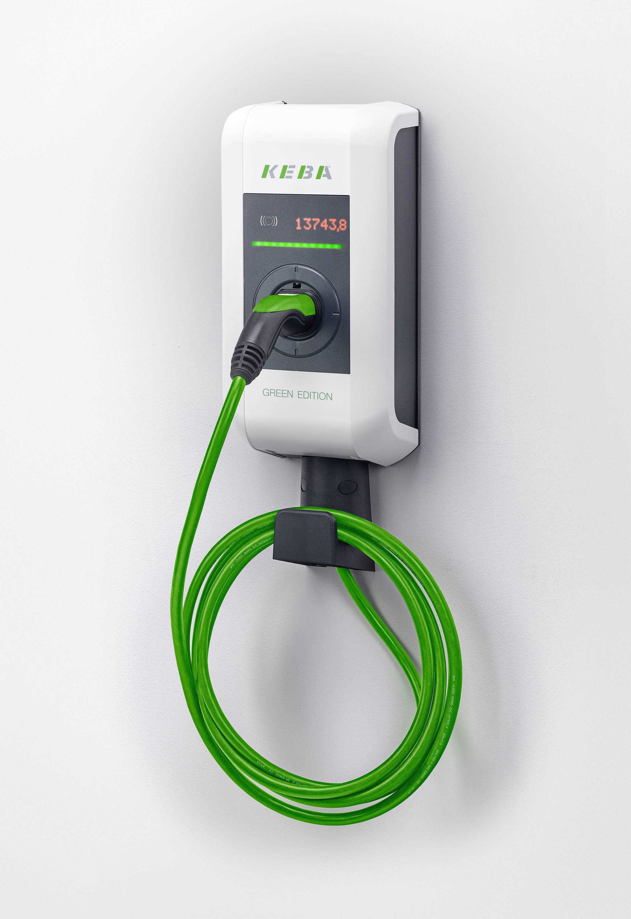 An der Wand montiertes KEBA-Elektrofahrzeug-Ladegerät mit hellgrünem Kabel, das darunter aufgewickelt ist, auf einfachem weißem Hintergrund.
