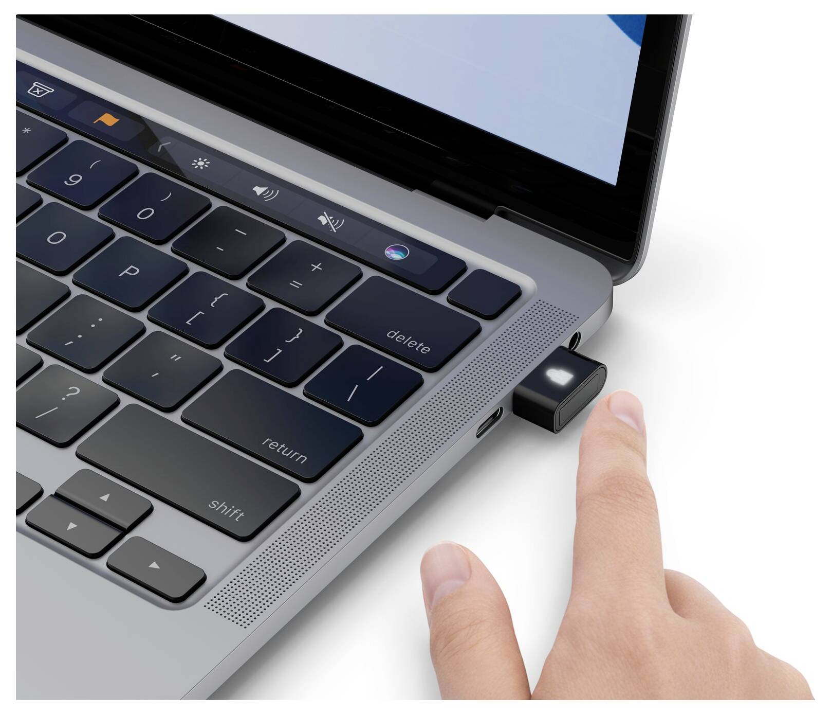 Hand, die einen USB-Stick in die Seite einer Laptop-Tastatur einsteckt.