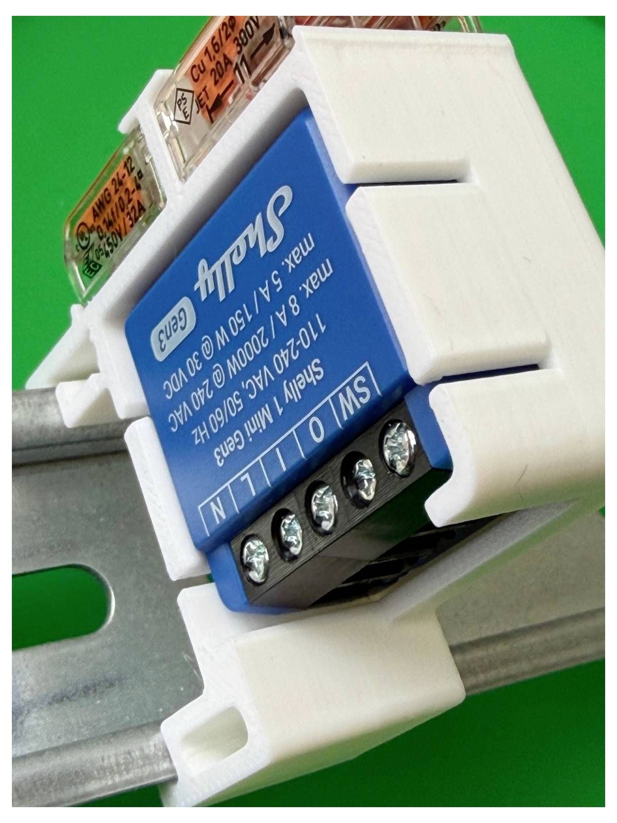 Nahaufnahme eines blauen DIN-Schienen-Elektroschaltermoduls mit Schraubklemmen, beschriftet mit „Switch" und „110-240V AC", montiert auf einer Metallschiene.