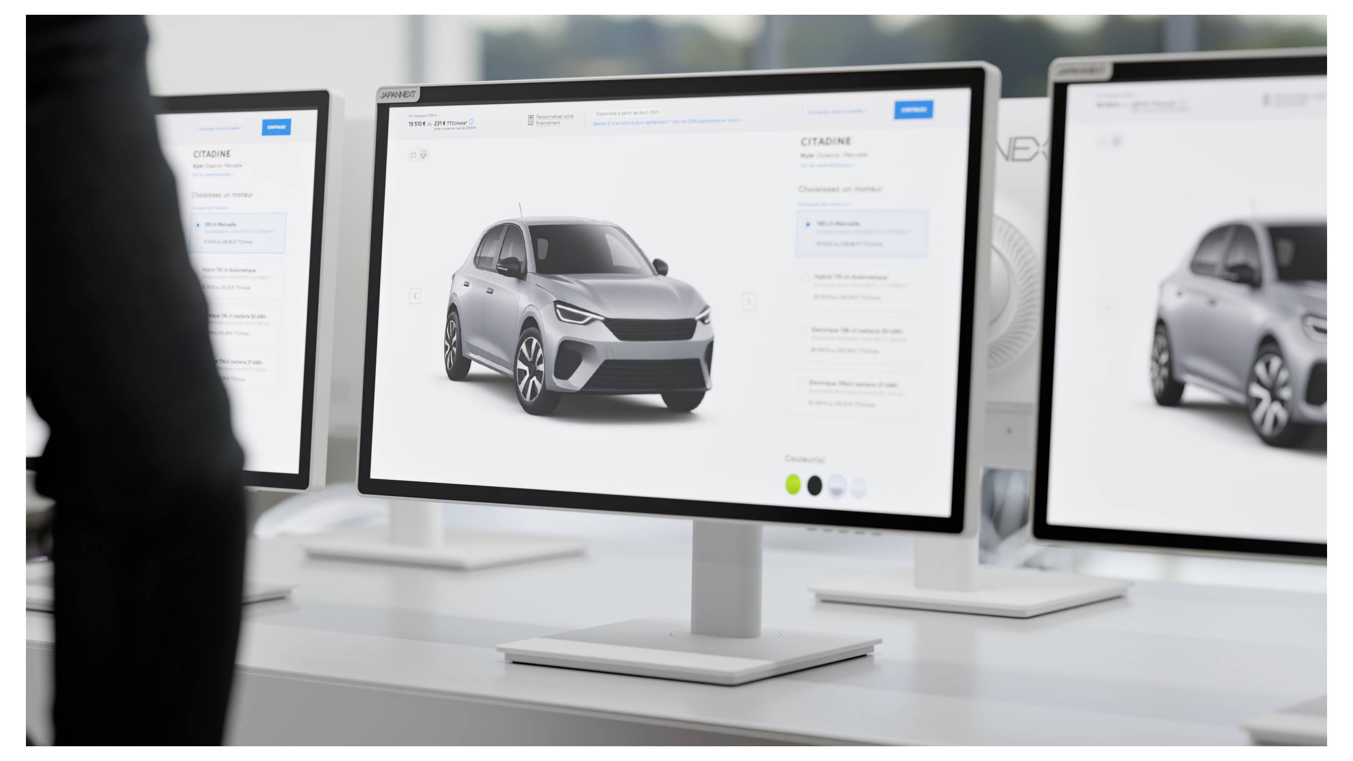 Mehrere Desktop-Monitore zeigen einen Autokonfigurator mit einem silbernen SUV auf einer weißen Benutzeroberfläche an, was auf eine Arbeitsstation für Automobildesign oder Verkauf hindeutet.
