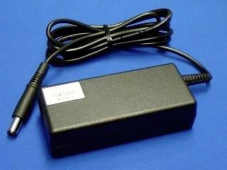 Schwarzer Stromadapter mit angebrachtem Kabel und Hohlsteckverbinder auf blauem Hintergrund.