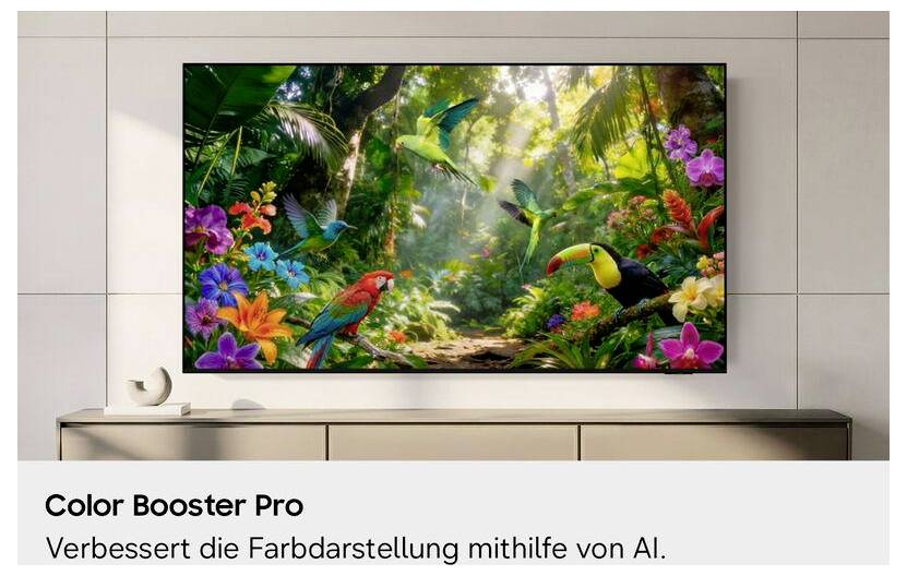 An der Wand montierter Fernseher zeigt eine lebendige tropische Dschungelszene mit bunten Vögeln und Blumen; die Beschriftung lautet „Color Booster Pro" und „Verbessert die Farbdarstellung mithilfe von AI."