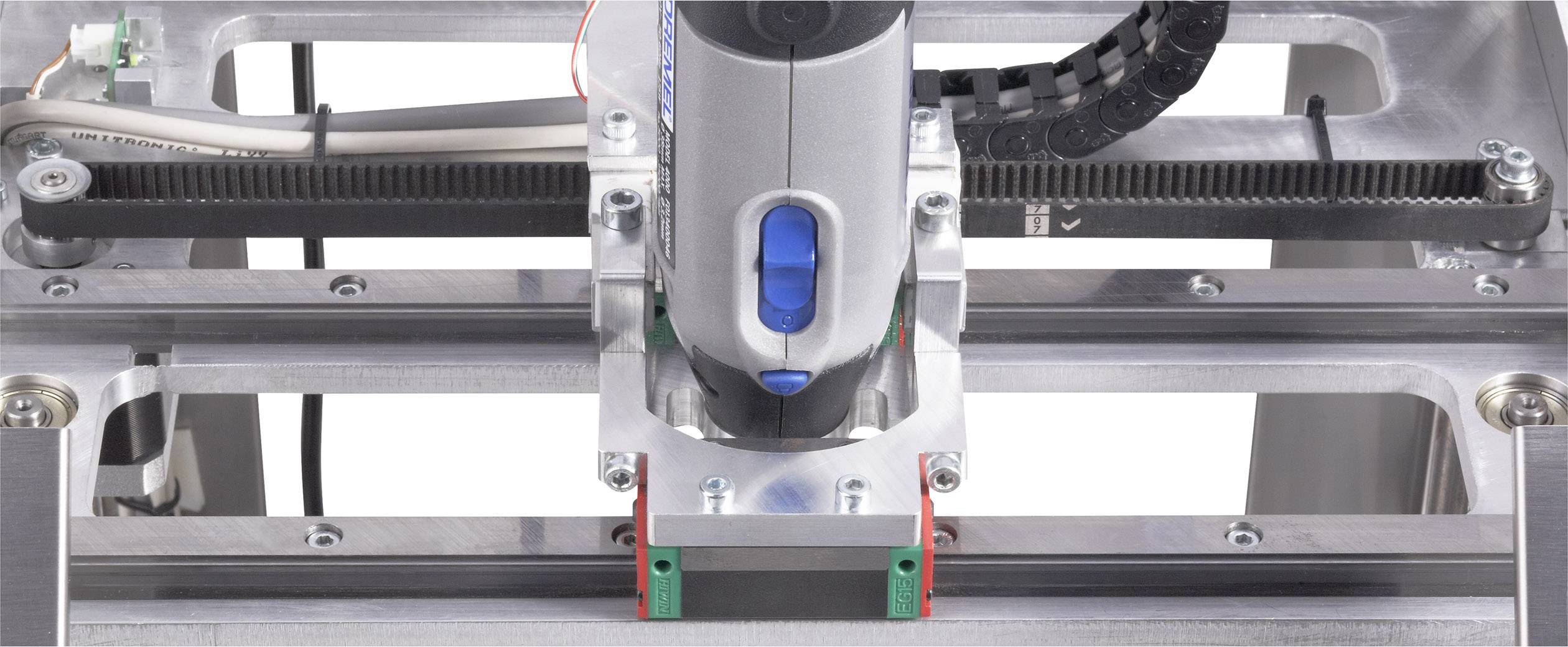 3D-Druckerkopf in Bewegung auf der X-Achse einer Metallplattform. Erzeugt mechanisch präzise Strukturen.