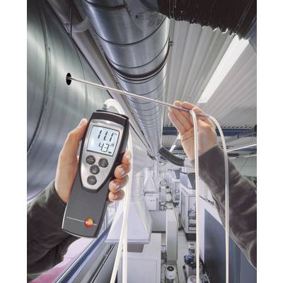 Eine Person misst mit einem Handgerät die Lufttemperatur und Feuchtigkeit in einem industriellen Lüftungssystem. Das Display zeigt '11°C' und '43%'.