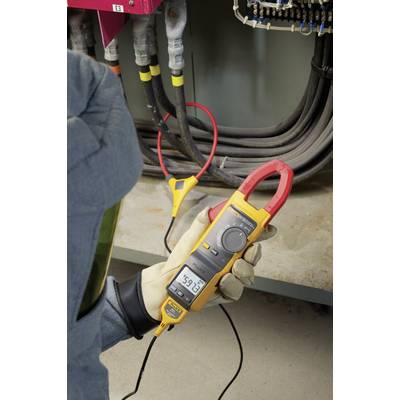 Eine Person misst mit einem gelben Multimeter den Strom an mehreren Kabeln in einem Schaltschrank. Das Display zeigt '591 A'.