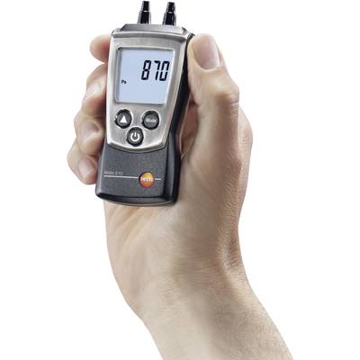 Eine Hand hält ein digitales Manometer, das '870 Pa' anzeigt. Das Gerät wird offenbar zur Messung des Drucks verwendet.