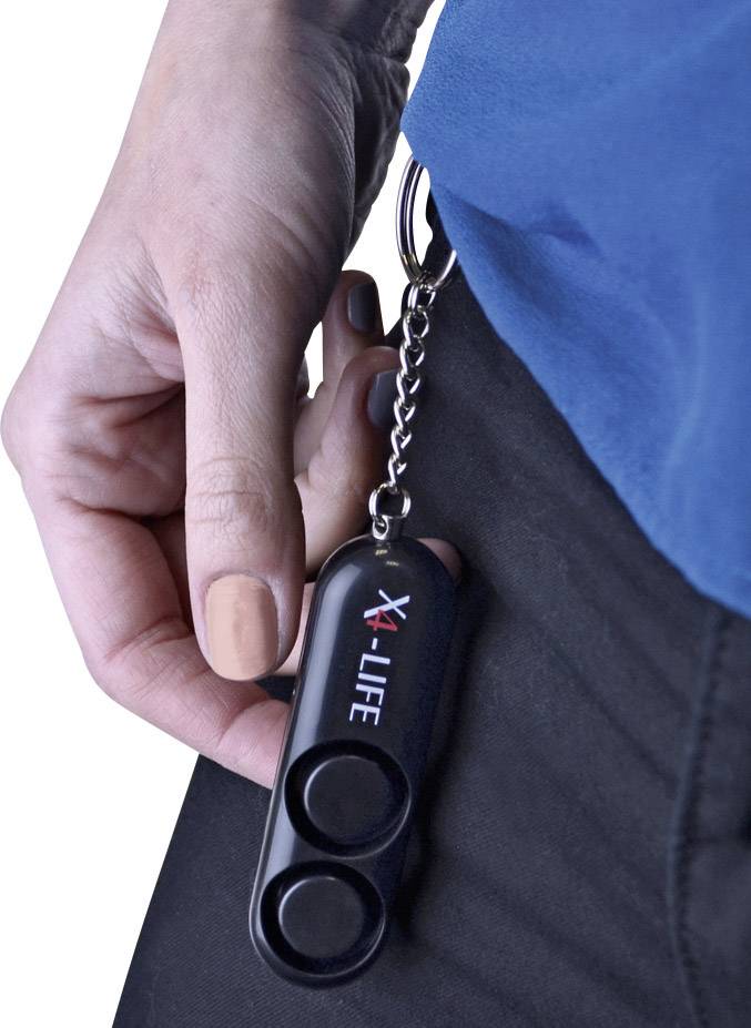 Eine Hand hält einen schwarzen X-LIFE-Schlüsselanhänger, der an einem Gürtel befestigt ist.