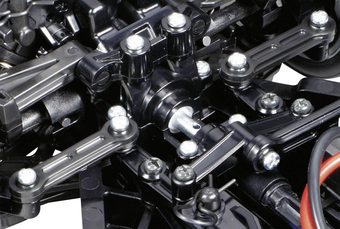 Nahaufnahme eines komplexen mechanischen Bauteils, möglicherweise Teil eines Modellautofahrwerks, mit schwarzen Verbindungen und Metallkomponenten.