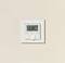 Ein moderner Thermostat an einer beigen Wand zeigt eine Temperatur von 21,0 Grad Celsius und die Uhrzeit 14:18 an.
