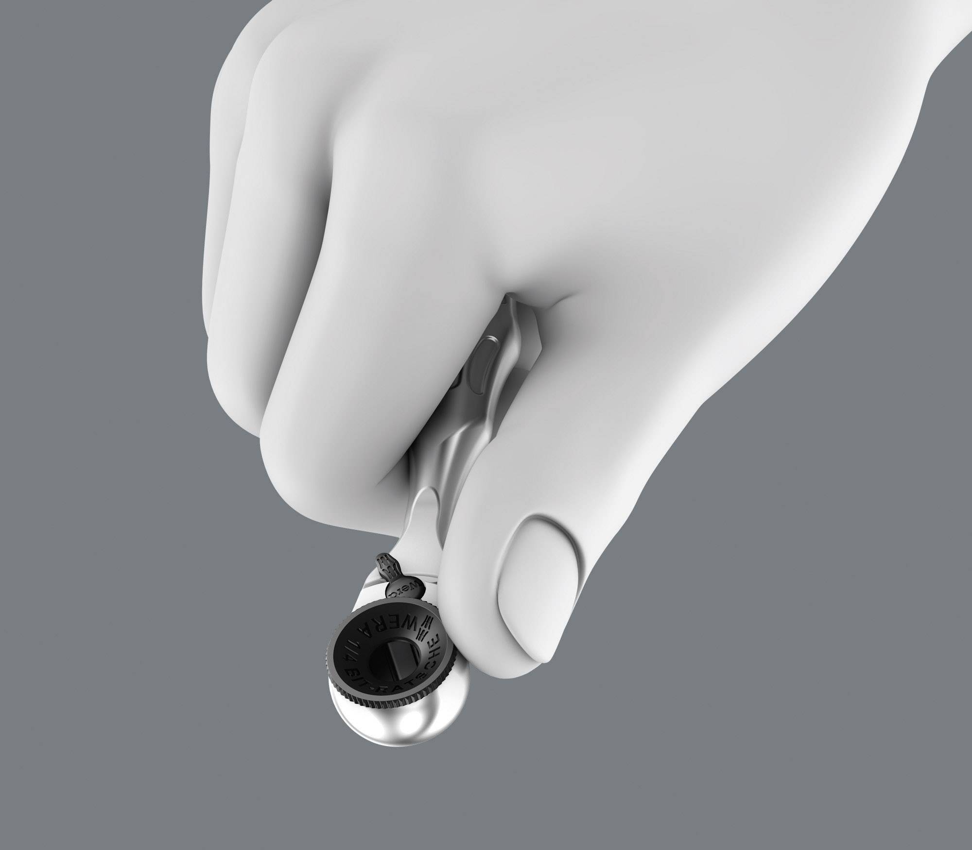 Eine weiße Hand hält ein Schraubenschlüssel mit einem schwarzen Kopf gegen grauen Hintergrund. Werkzeug wird präzise gezeigt.