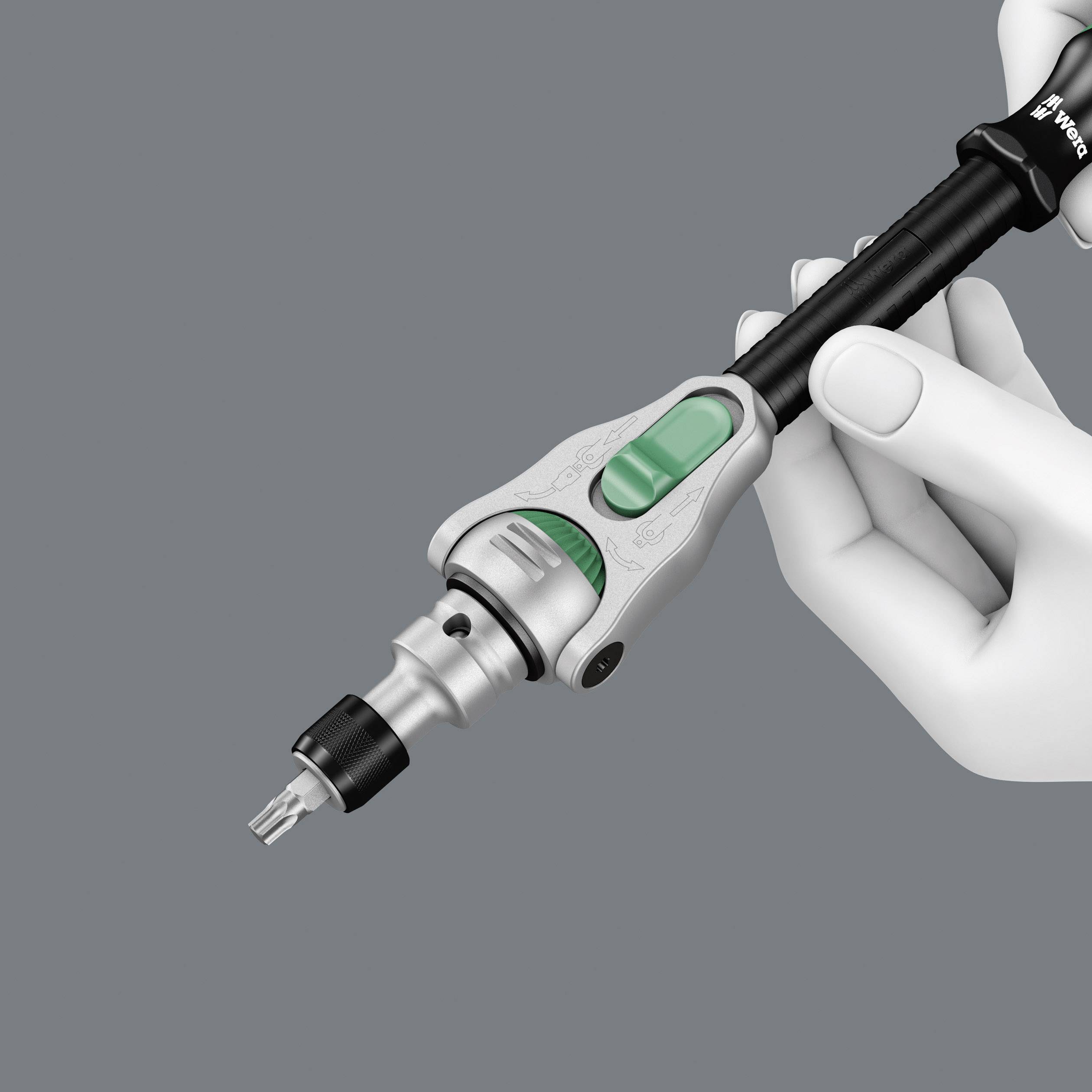 Eine weiße behandschuhte Hand hält ein chirurgisches Elektrogerät mit grünem Schalter auf grauem Hintergrund.