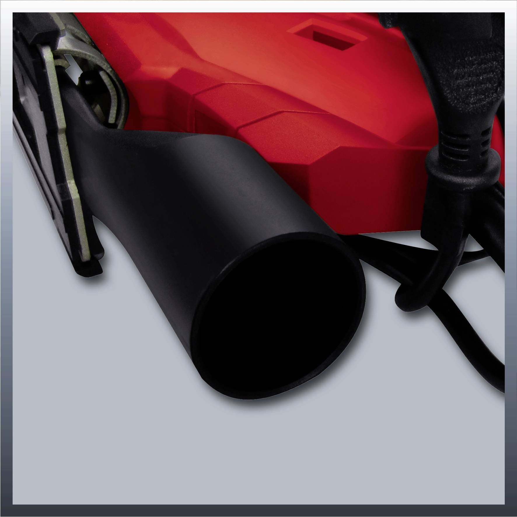 Ein schwarzer Haarföhn und ein rotes Gehäusegerät liegen übereinander, verbunden durch ein schwarzes Kabel.